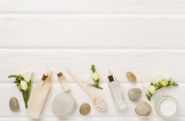 Tahta arka planda kaplıca ürünleri ve çiçeklerle yatıyordu