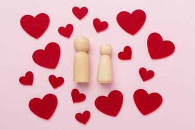 Renkli arka planda birbirine aşık ahşap bir çift. Yaratıcı Sevgililer Günü kompozisyonu