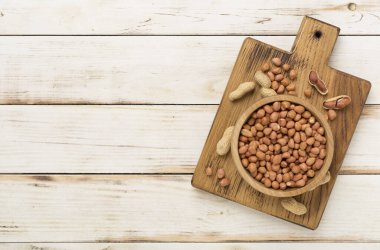 Ahşap arka planda soyulmuş ve soyulmamış fıstıklar.