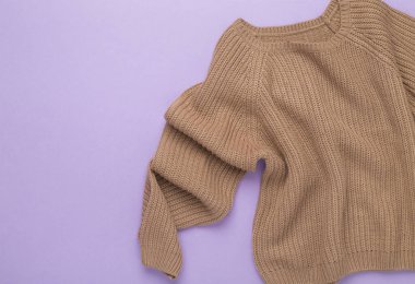 Renkli arka planda bej örülmüş süveter, üst görünüm