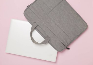 Renkli arka planda aygıtı olan gri renkli dizüstü bilgisayar çantası, üst görünüm