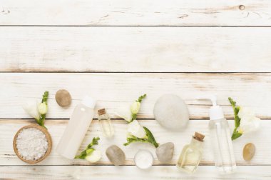 Tahta arka planda kaplıca ürünleri ve çiçeklerle yatıyordu