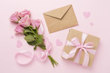 Kalpli pembe güller ve renkli arka planda hediye, üst manzara. Sevgililer Günü konsepti