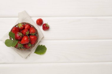 Çilekler kasede, ahşap arka planda, üst manzara.