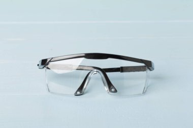 Ahşap masada siyah güvenlik gözlükleri.