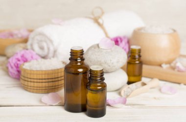 Ahşap masanın üzerinde pembe güller olan spa kompozisyonu