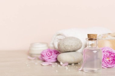 Ahşap masanın üzerinde pembe güller olan spa kompozisyonu