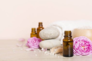 Ahşap masanın üzerinde pembe güller olan spa kompozisyonu