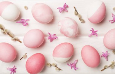 Ahşap arka planda dekoru olan pembe Paskalya yumurtaları.
