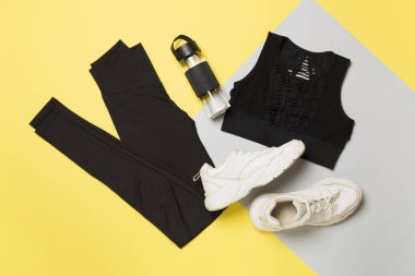 Renkli arka planda siyah spor kıyafeti, üst görünüm