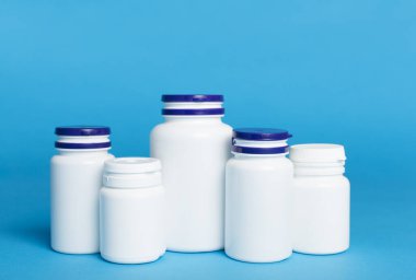 Renk arkaplanındaki vitaminler için plastik şişeler