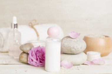 Ahşap masanın üzerinde pembe güller olan spa kompozisyonu