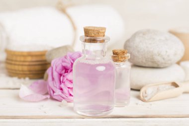 Ahşap masanın üzerinde pembe güller olan spa kompozisyonu