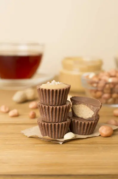 Tasty chocolate peanut butter cups on wooden table