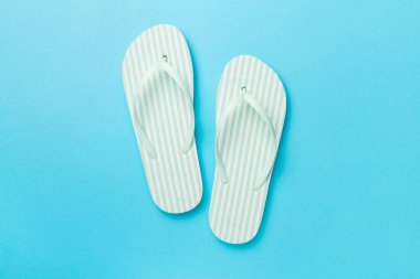 Ahşap arka planda çizgili parmak arası terlikler, üst görünüm