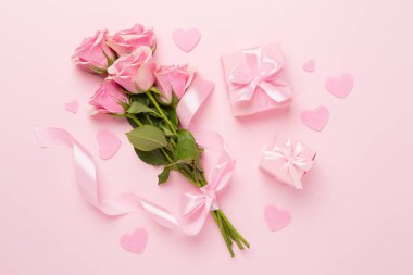 Kalpli pembe güller ve renkli arka planda hediye kutusu, üst manzara. Sevgililer Günü konsepti
