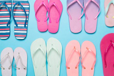 Renk arkaplanı ve üst görünümde birçok parlak parmak arası terlik