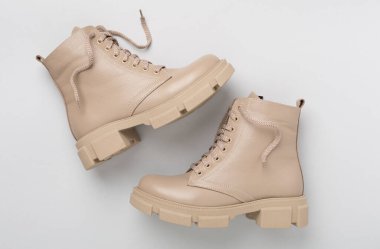 Renk arkaplanında bej renkli moda çizmeler, üst görünüm.