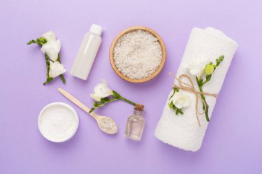 Renkli arka planda spa ürünleri ve çiçeklerle düz yatıyordu