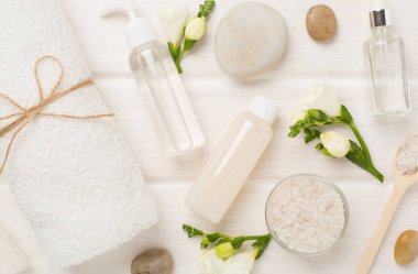 Tahta arka planda kaplıca ürünleri ve çiçeklerle yatıyordu