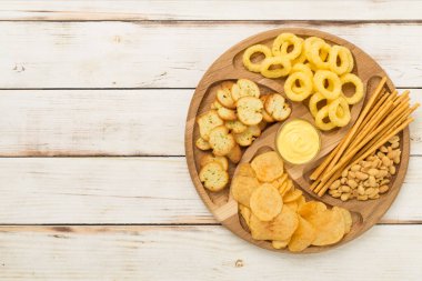 Ahşap arka planda çeşitli sağlıksız atıştırmalıklar.