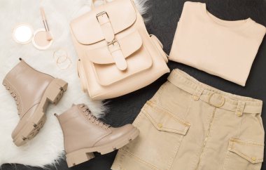 Beton arka planda modaya uygun bahar kıyafetleriyle yatıyordu.