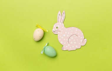 Renkli arka planda şirin Paskalya tavşanı ve yumurtalar.