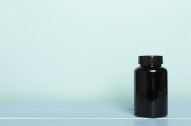 Tahta masadaki vitaminler için plastik şişe.