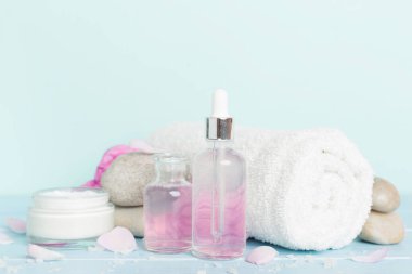 Ahşap masanın üzerinde pembe güller olan spa kompozisyonu