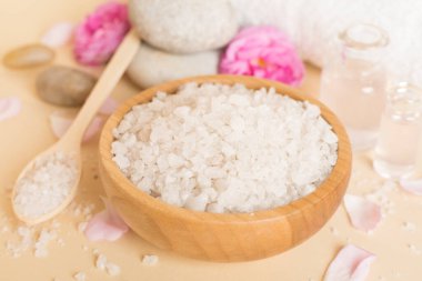 Ahşap masanın üzerinde pembe güller olan spa kompozisyonu