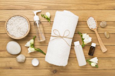 Tahta arka planda kaplıca ürünleri ve çiçeklerle yatıyordu