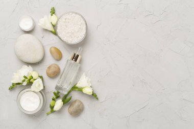 Beton zemin üzerinde spa ürünleri ve çiçeklerle yatıyordu