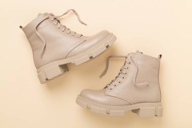 Renk arkaplanında bej renkli moda çizmeler, üst görünüm.