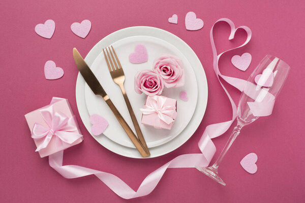 Накрытие праздничного стола на День Святого Валентина на цветном фоне, вид сверху