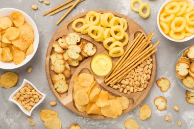 Beton arka planda çeşitli sağlıksız atıştırmalıklar, üst manzara