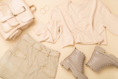 Renkli arka plan ve üst görünümde modaya uygun bahar kıyafetiyle düz uzandı