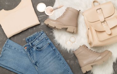 Beton arka planda modaya uygun bahar kıyafetleriyle yatıyordu.