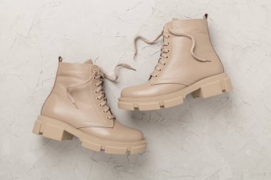 Beton arka planda bej renkli moda çizmeler, üst görünüm.