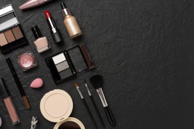 Beton zemin üzerinde makyaj ürünleri ve araçları ile düz yatıyordu