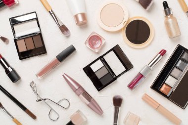 Beton zemin üzerinde makyaj ürünleri ve araçları ile düz yatıyordu
