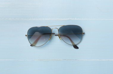 Ahşap zemin üzerinde güneş gözlüğü, üst görünüm.