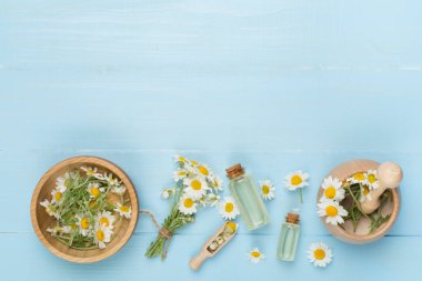 Ahşap arka planda gerekli yağ ve papatya çiçekleri ile kompozisyon, üst görünüm