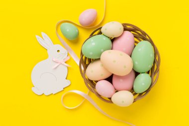 Renkli arka planda yumurtaları olan Paskalya tavşanı.