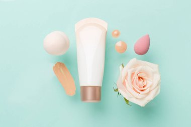 Renk arkaplanında makyaj temeli olan kompozisyon, üst görünüm