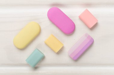 Colorful eraser on wooden backgroung, top view clipart