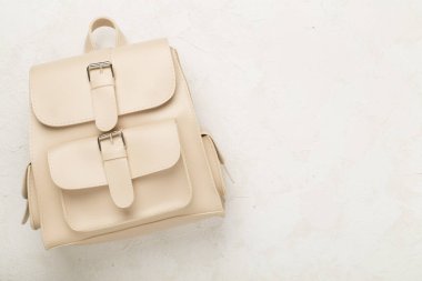 Beton zemin üzerinde bej renkli stil sırt çantası, üst görünüm.