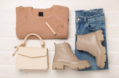 Ahşap arka planda modaya uygun bahar kıyafetleriyle yatıyordu.