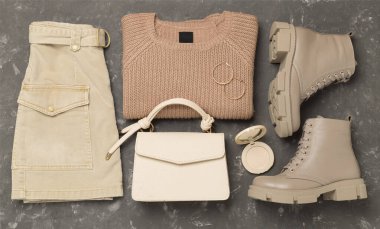 Beton arka planda modaya uygun bahar kıyafetleriyle yatıyordu.