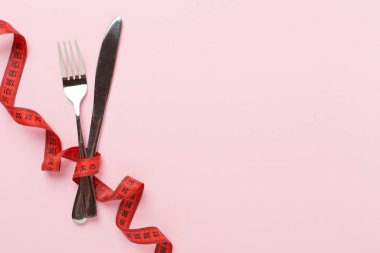 Arka planda çatal ve bıçakla mezuranın ölçüsü, üst, görüş. Kilo kaybı konsepti