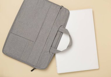 Renkli arka planda aygıtı olan gri renkli dizüstü bilgisayar çantası, üst görünüm